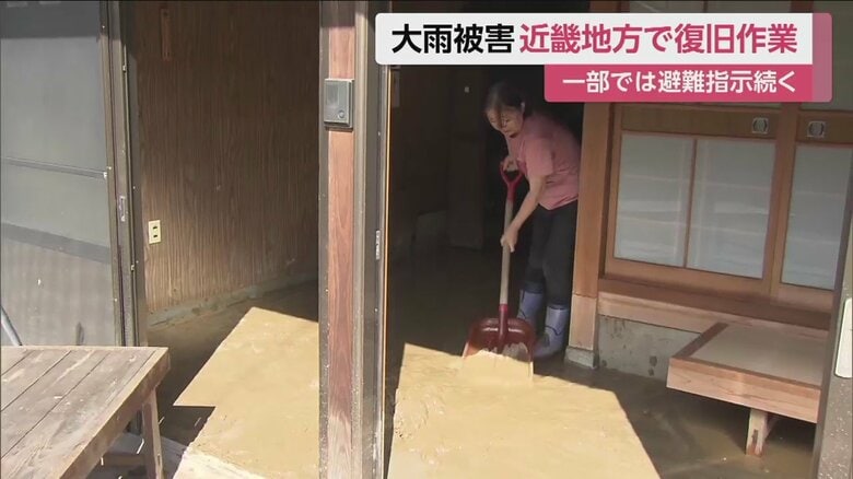 家に入り込んだ土砂をかき出す住民（京都・綾部市）