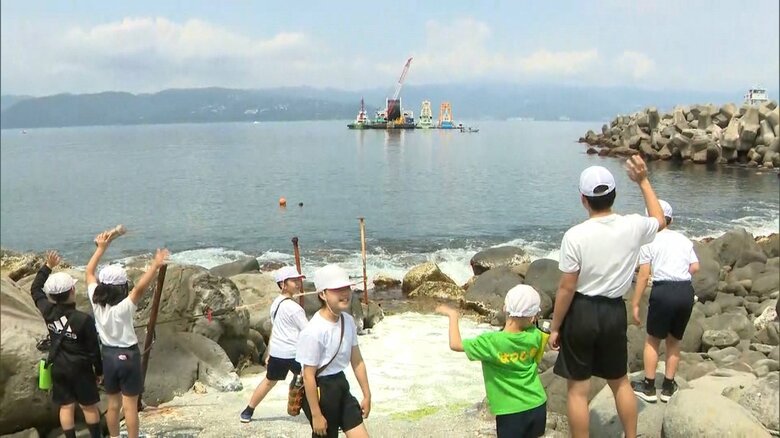 送水管設置工事を見学する初島の小学生