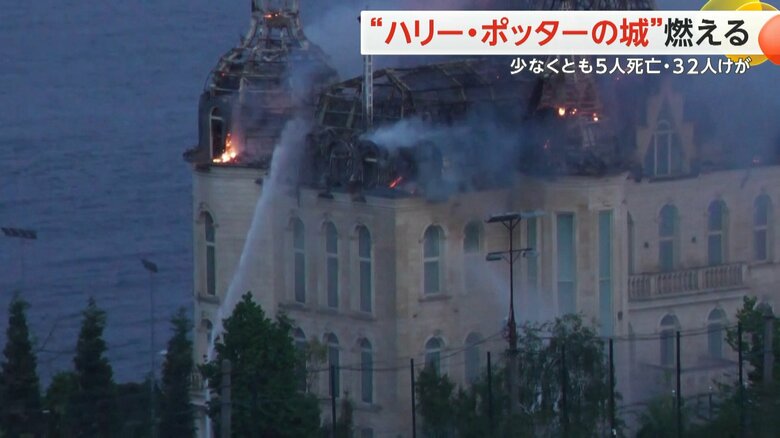 オレンジ色の炎が上がる“ハリー・ポッターの城”に放水を行う様子