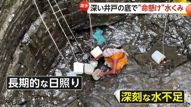 井戸の底でわずかにしみ出てきた水をすくう女性