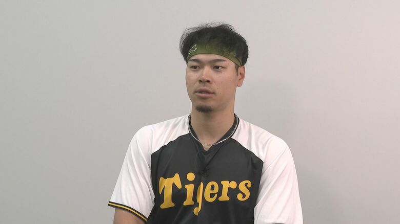 インタビューに応える佐藤輝明