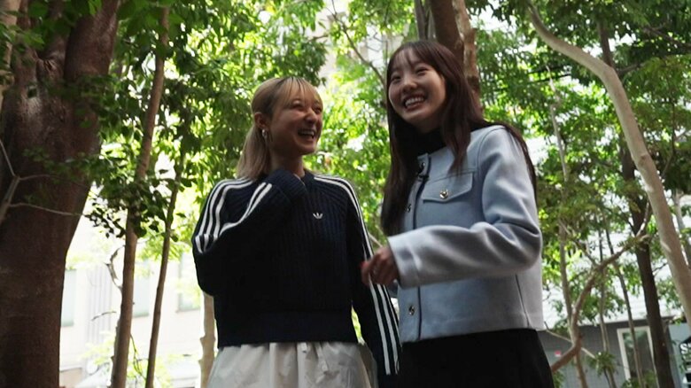 カフェ前を笑い合いながら歩く2人