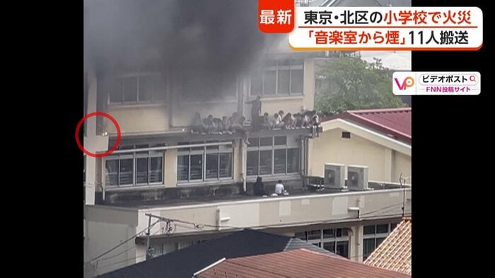 ひさしに取り残された子どもたち…その横に落下物が（赤丸）