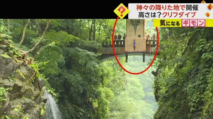 滝よりも高い場所にある飛び込み台に立つ女性