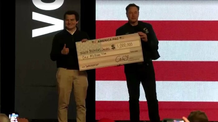 有権者に100万ドルの小切手を手渡すイーロン・マスク氏(3月30日)