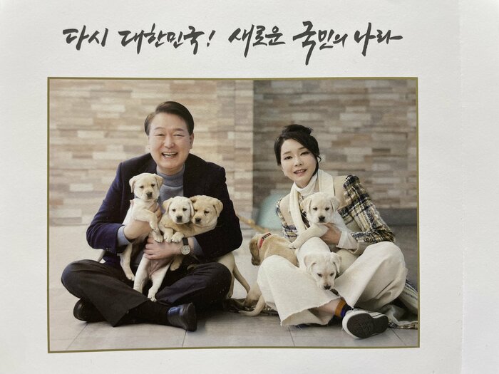 2024年の年賀状で子犬を抱く大統領夫妻