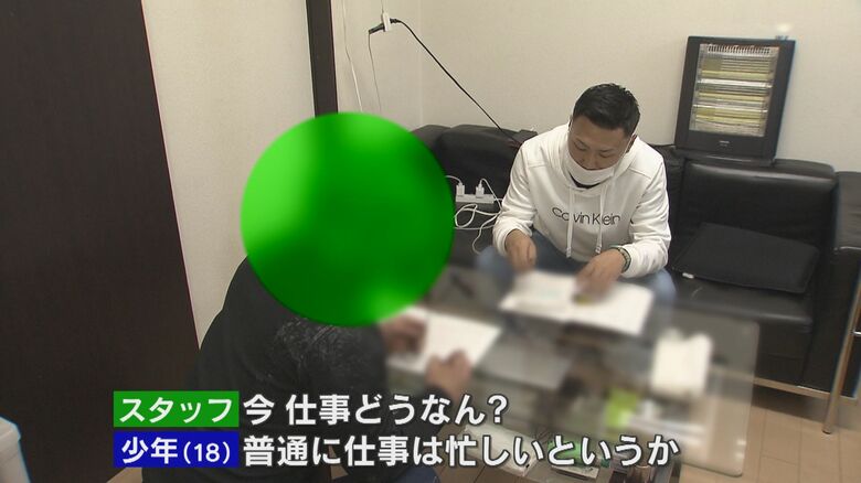 仕事から施設に返ってきた少年と言葉を交わす工藤さん