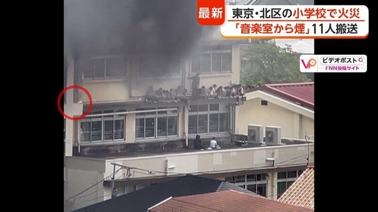 ひさしに取り残された子どもたち…その横に落下物が（赤丸）
