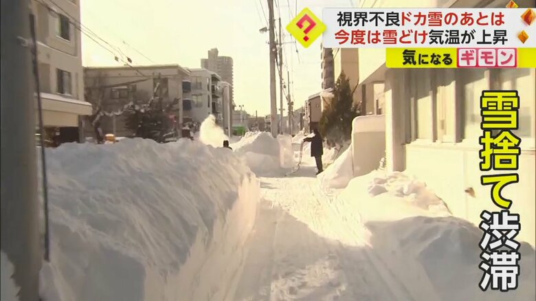雪かきされた道路の両脇に高く雪が積もっている