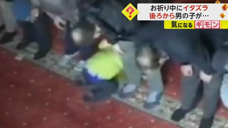 足元で寝転がっている男の子（IHA）