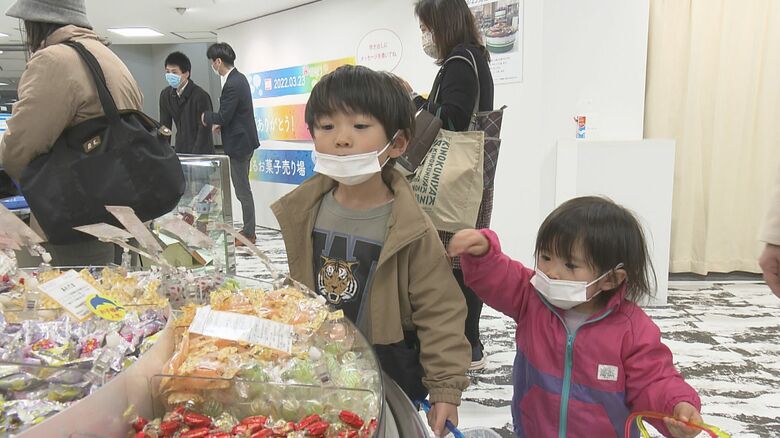 回るお菓子売り場を前に目が輝く子供たち