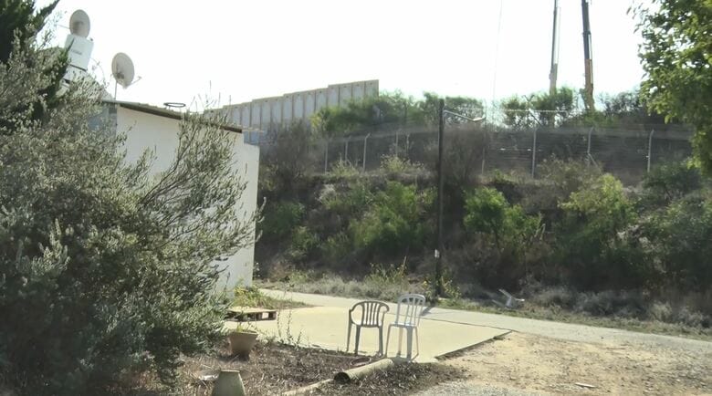 白い家の庭先数十メートルにガザとを隔てる壁が