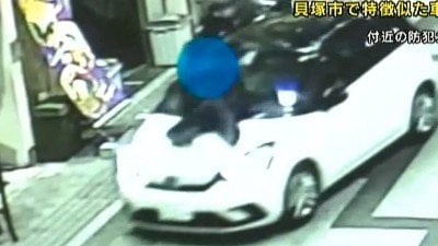 警察官をボンネットに乗せて走る車（付近の防犯カメラより）