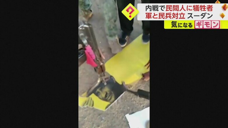 看板に描かれた敵側のトップの人物に銃を突きつける兵士