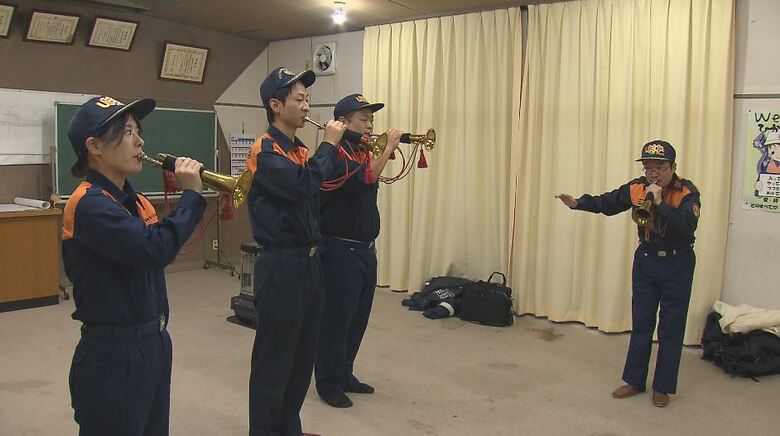 上田市消防団の消防ラッパ訓練に参加する国井さん（左）