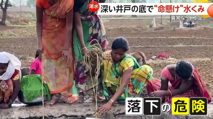 井戸のへりギリギリからロープを垂らす女性