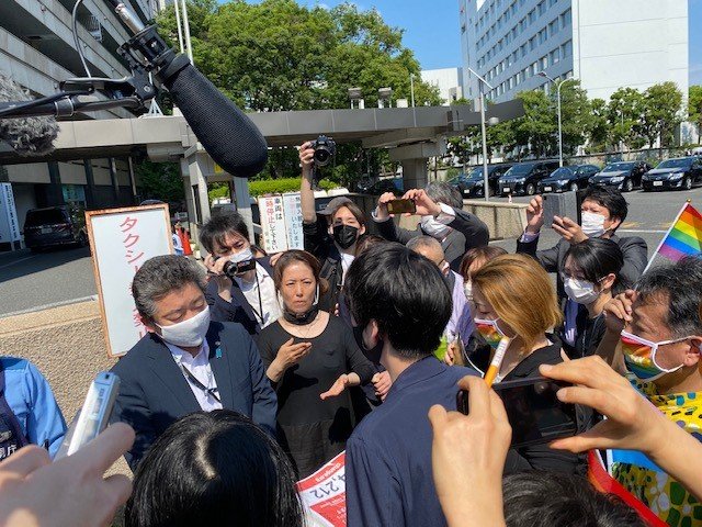 自民党側に署名を渡す松岡さん