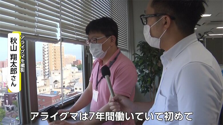 佐賀市白山のアーケードに並ぶ空き家の屋根上にいたアライグマの集団を写真に収めた秋山翔太郎さん