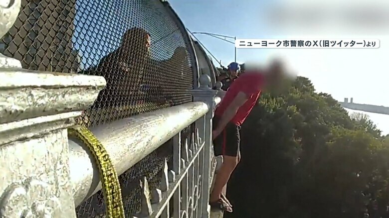 陸橋の外側に立ち今にも飛び降りそうな男性
