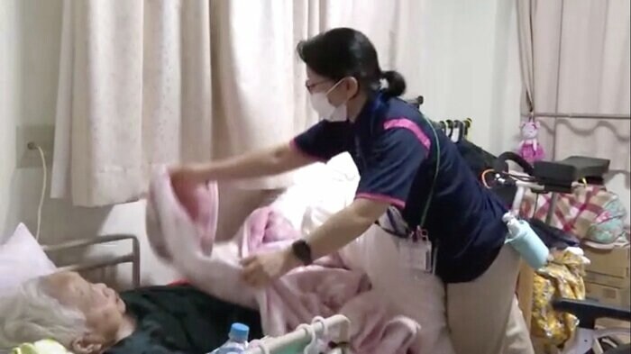 就寝前の安否確認を行う介護士の安村幸恵さん