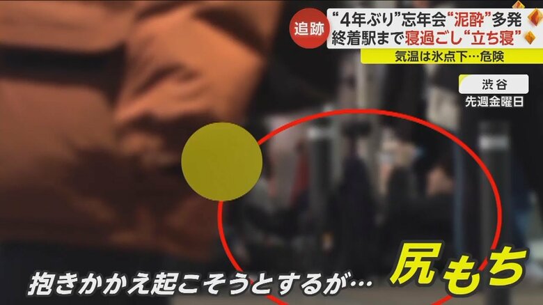 泥酔し座り込む人を介抱する人もつられて尻もちをついていた