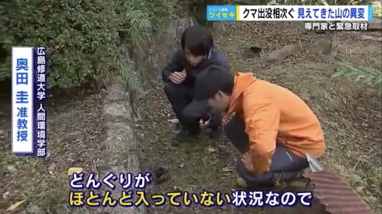 クマのフンを観察する奥田准教授（右）と五十川記者（左）