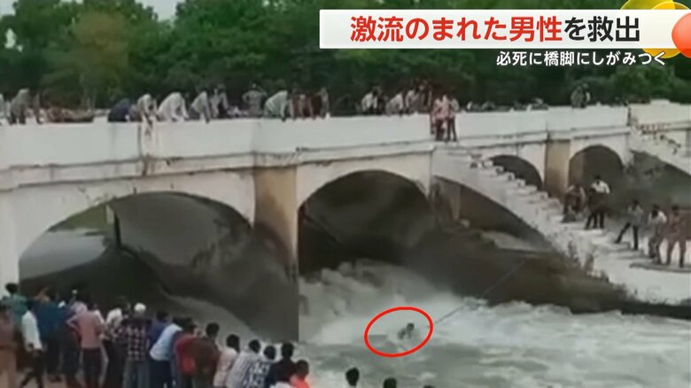 激流にのまれた男性が橋脚から手を離し、川岸へ引き上げられる救助の瞬間①