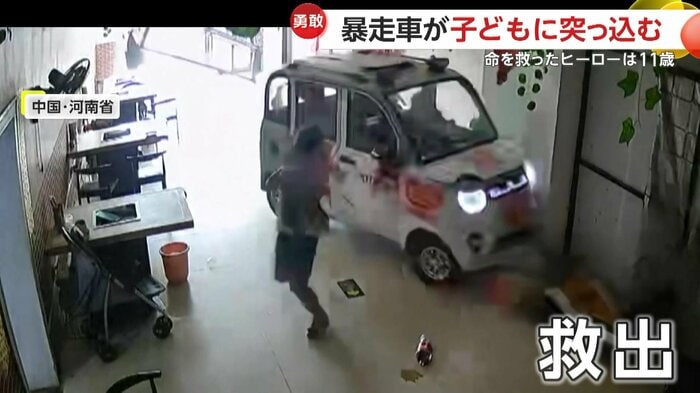 子どもを抱え上げて救出する少女