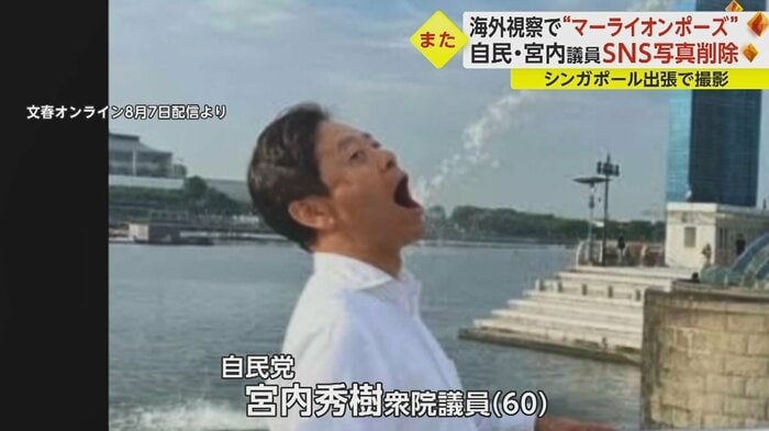 マーライオンの口から出る噴水を飲むかのようなポーズ