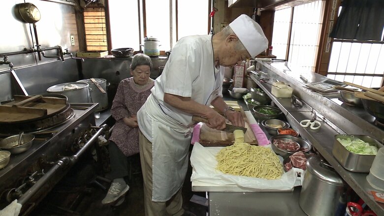 麺の仕込みをする金さんとその様子を見つめる栄子さん