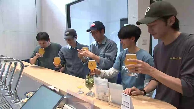 初仕込みのビールが完成しスタッフがその味を確かめる