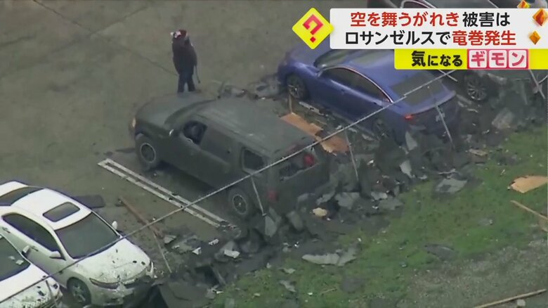 車の周りを人が歩き、被害を確認している(画像:Raymond Rodriguez)