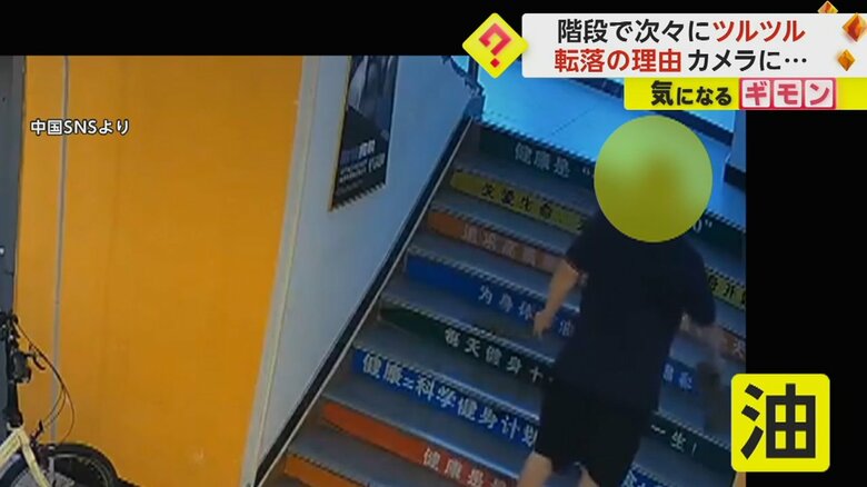 男が階段に油をまく