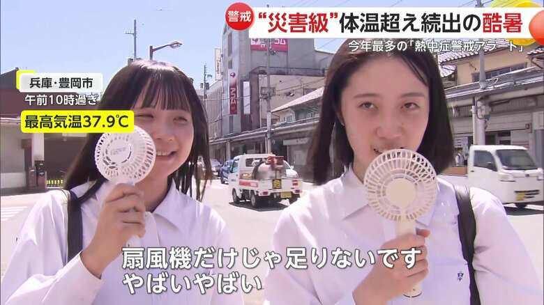 兵庫・豊岡市でハンディー扇風機を手に涼を取る学生