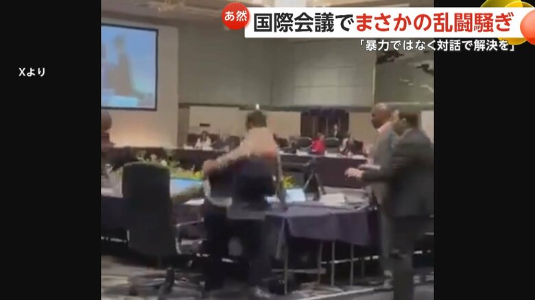 ベージュのスーツの男性を投げ飛ばす紺色のスーツの男性