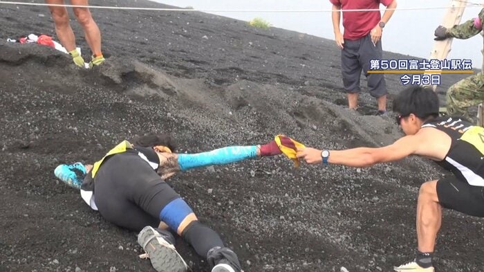 急勾配を転がり落ちながらタスキを渡す