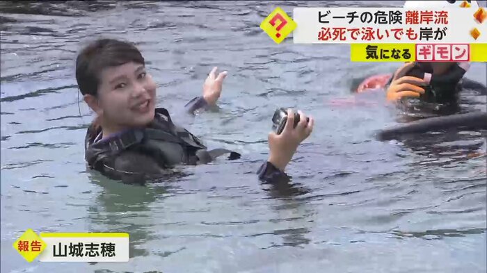 海に入ってリポートする記者