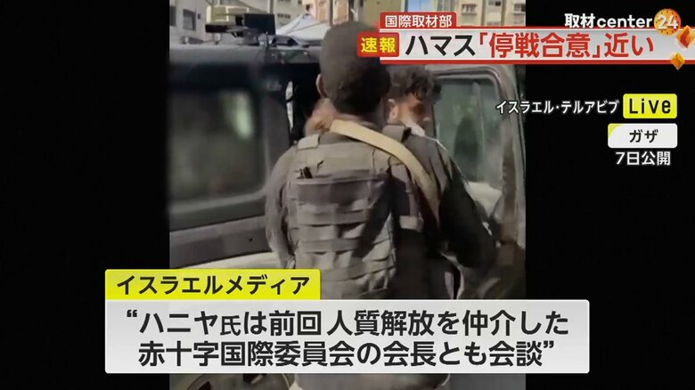 押し込むように人質を車に乗せる兵士