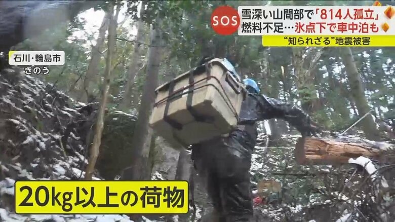 20kg以上の荷物を背負い急斜面を進むボランティア