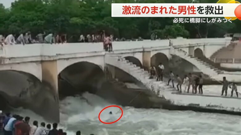 激流にのまれた男性が橋脚から手を離し、川岸へ引き上げられる救助の瞬間②