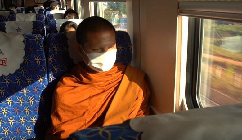 信心深い仏教徒が多いラオス。車内にはオレンジ色の袈裟の僧侶も