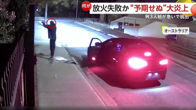 何やら液体を住宅にかける黒ずくめの男