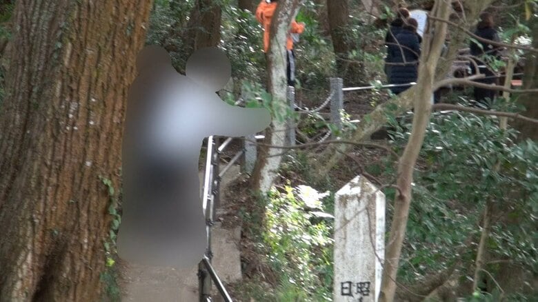 泉に向かって硬貨らしきものを投げ込む人