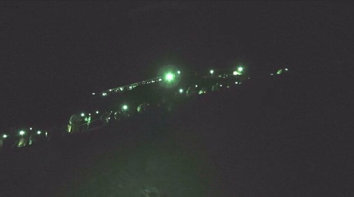 ヘッドライトを着けた登山客で渋滞する登山道