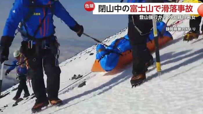 凍結した斜面を搬送する救助隊