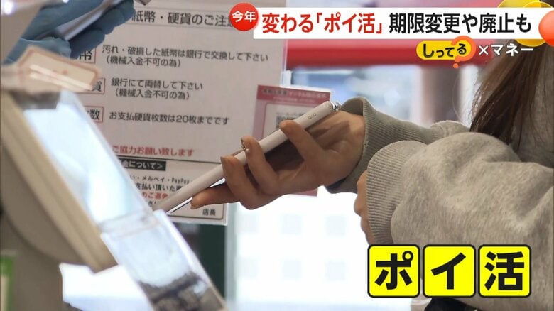 レジで携帯を提示して買い物を行う客