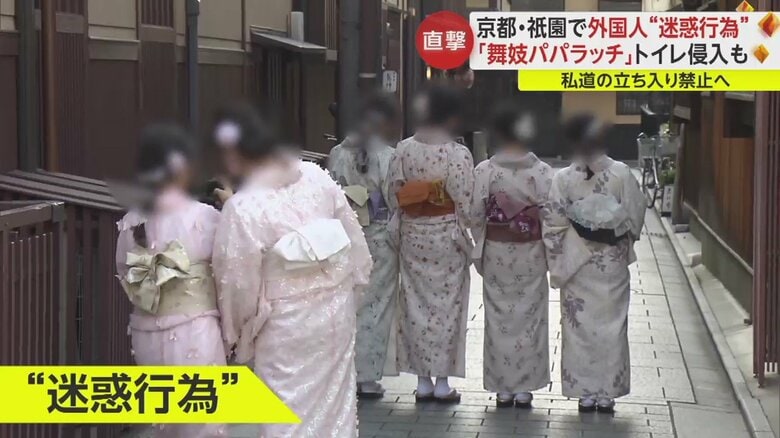 外国人観光客たちが横に広がり、細い道をふさいで写真撮影