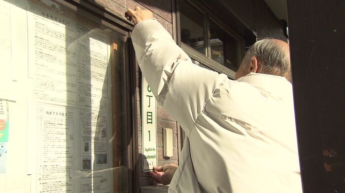 自ら表示板を付け替える高橋さん