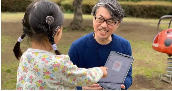 公園でアプリを使って愛娘に言葉を教える吉岡講師(本人提供)
