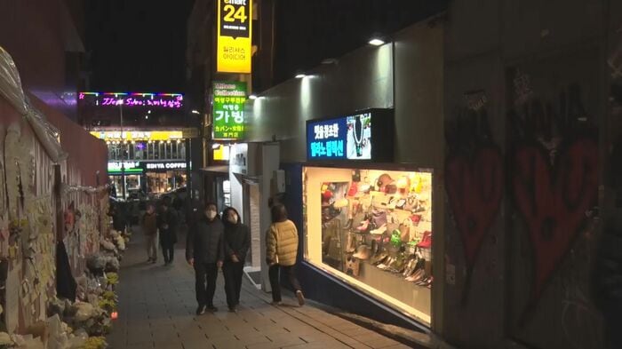 ナムさんが営む店のショーウィンドーの灯りが暗い現場路地を照らしている